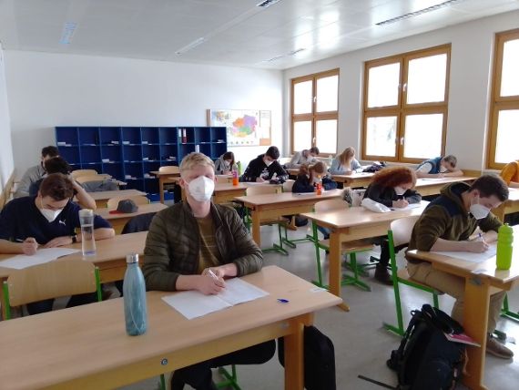 Schülerinnen und Schüler bei einer Prüfungssituation in der Klasse