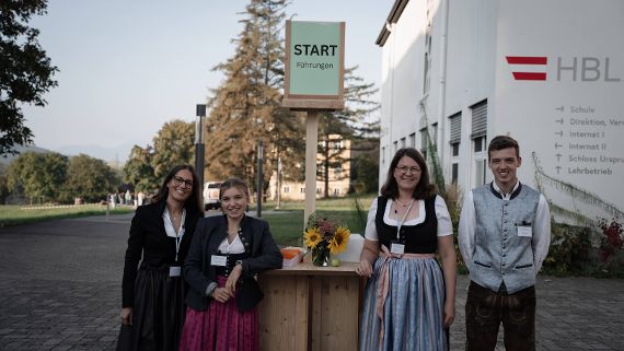 Foto mit einer Gruppe von Personen vor Schulgebäude