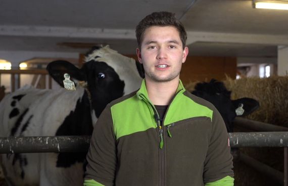 Ein Schüler mit einer Kuh im Hintergrund bei Interview.